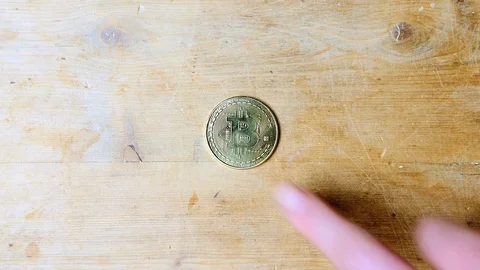 Man using one gold BTC bitcoin crypto currency to buy something on table  Stock Footage 85688563
