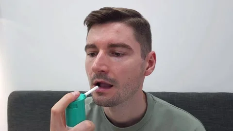 Man using oral spray for throat relief at home. Health care and hygiene Stock Footage 284042146