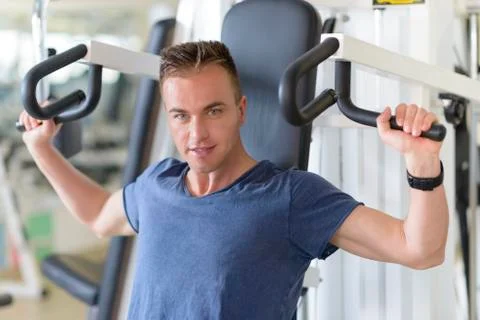 Man using pectoral machine at gym Stock Photos