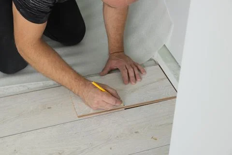 Man using pencil during installation of new laminate flooring, closeup Stock Photos