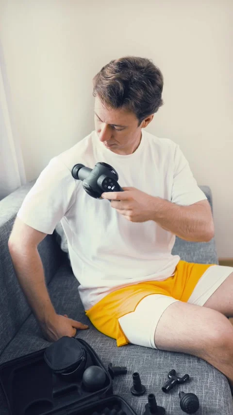 Man using a percussion massage gun on his shoulder for myofascial release, muscl Video stock 343752696