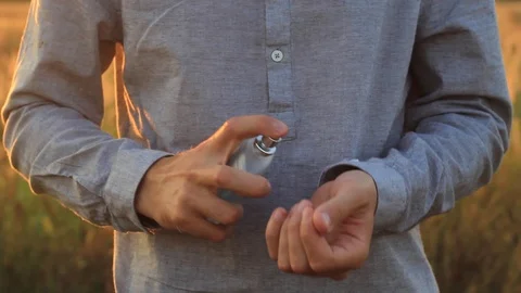 Man using perfume at a beautiful sunset Stock Footage 94170228