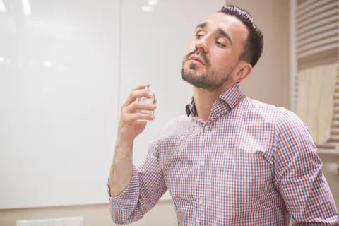 Man using perfume before date Stock Photos