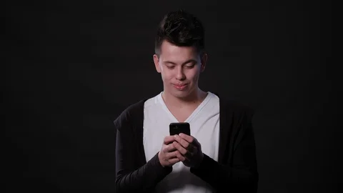 A Man Using a Phone Against a Black Background Stock Footage 87293639