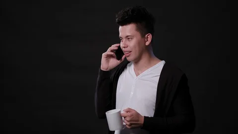 A Man Using a Phone Against a Black Background Stock Footage 87299577