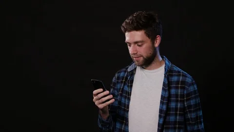 A Man Using a Phone Against a Black Background Stock Footage 88377060