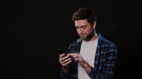 A Man Using a Phone Against a Black Background Stock Footage 88379187