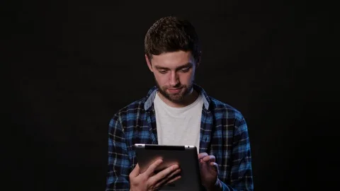 A Man Using a Phone Against a Black Background Stock Footage 88412092
