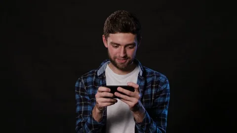 A Man Using a Phone Against a Black Background Stock Footage 88412245