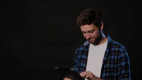 A Man Using a Phone Against a Black Background Stock Footage 88412510