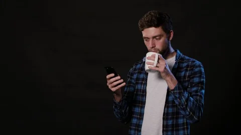 A Man Using a Phone Against a Black Background Stock Footage 88413049