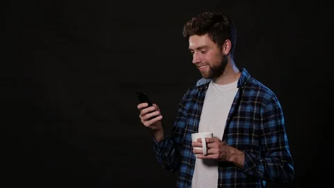 A Man Using a Phone Against a Black Background Stock Footage 88413160