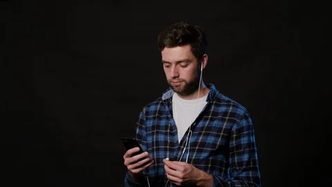 A Man Using a Phone Against a Black Background Stock Footage 88414069