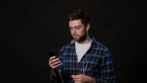 A Man Using a Phone Against a Black Background Stock Footage 88414258