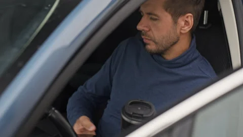 Man using phone and drinking coffee in car Stock Footage 340489839
