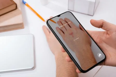 Man using a phone app to recognize skin problems on his hand Stock Photos