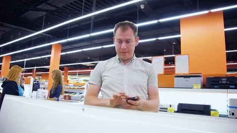 Man using phone in the appliance store Stock Footage 78222664