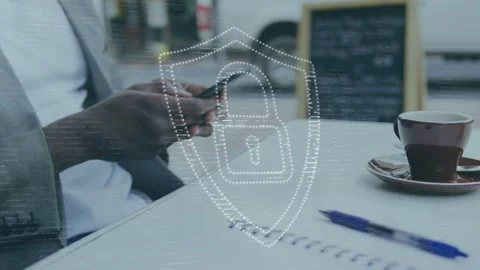 Man using phone at cafe, causing security shield overlay fading and pulsing over Stock Footage 335761993