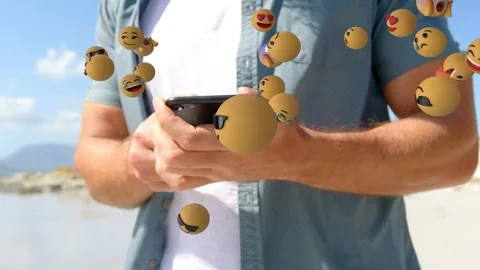 Man using phone, causing 3D emojis appearing from right and clustering around Stock Footage 335283019