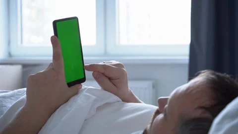 Man using phone chroma key green screen typing text reading social media closeup Stock Footage 170128955