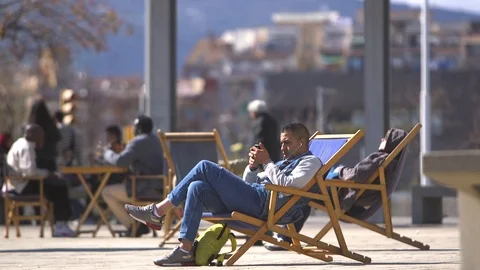 Man Using Phone In A Deck Chair Stock-Footage 127100099