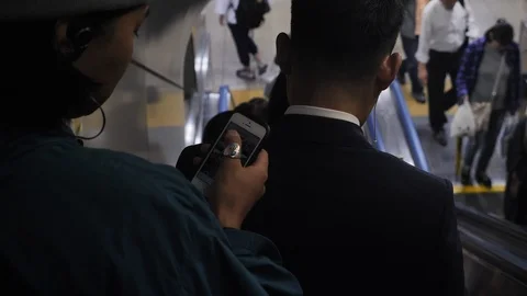 Man using Phone on Escalator  Osaka Station  Japan  4K Stock-Footage 104077692