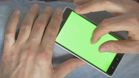 Man using phone with green screen. Shot on a digital camera in 4K, so you can Stock Footage 73975454