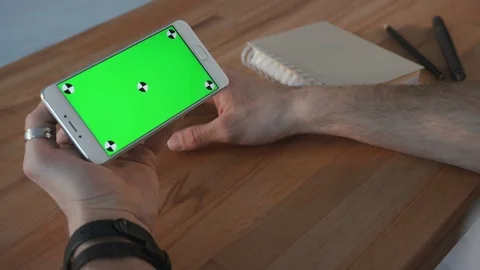Man using phone with green screen display at desk Stock Footage 87813904