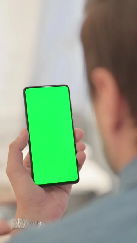 Man Using Phone with Green Screen, vertical video Видео 328564899