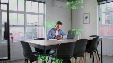 Man using phone, laptop, placing phone, writing notes, green data floating over Stock Footage 333368349