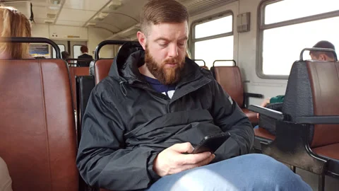 Man is using phone sitting in the train. Stock Footage 188843935