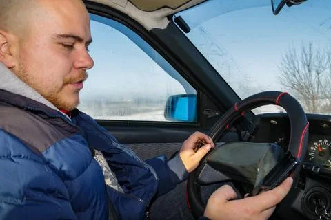 Man using phone while driving the car. Inside view Stock Photos