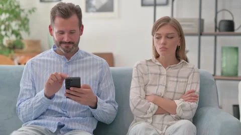 Man Using Phone while Stressed Wife Sitting aside on Sofa Video stock 287894745
