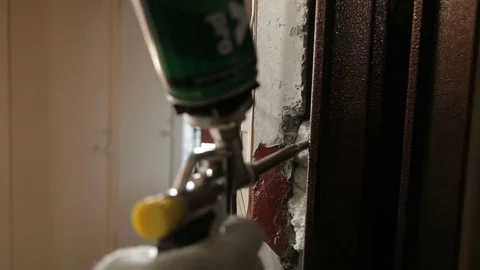 Man using polyurethane foam for installing new door Stock Footage 70913556