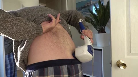 Man using portable back massager to ease sciatic pain Stock Footage 147091559