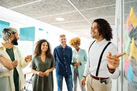 Man using post-its to explain ideas in a coworking Stock Photos