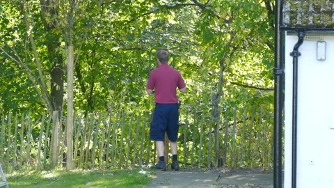 Man using a post rammer to drive a thick wooden stake into the ground. 스톡 동영상 119589377
