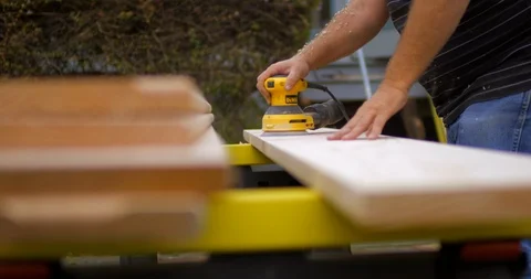 Man using a power sander on a piece of wood Vidéo 88369482
