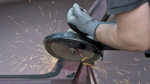 A man using a power tool - an angle grinder. Close-up shot Stock Photos