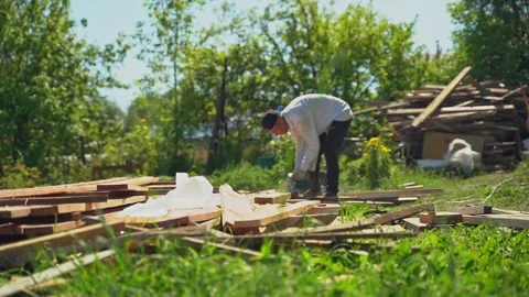 Man using power tool outdoors sawing boards Stock Footage 305900155