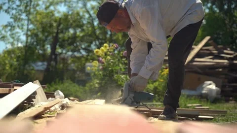 Man using power tool outdoors sawing boards Stock Footage 305900175
