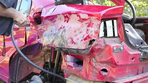 Man using a power tool on a wrecked Dodge Charger bending metal portapower Stock Footage 149277467