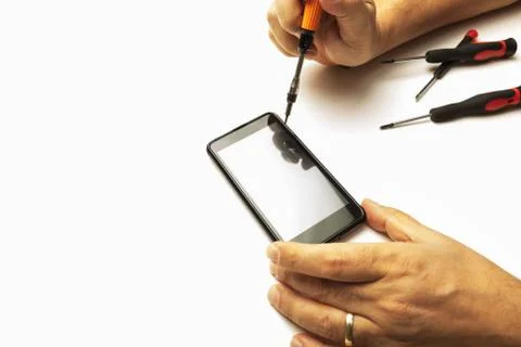 Man using precision screwdrivers on his smartphone.. Stock Photos