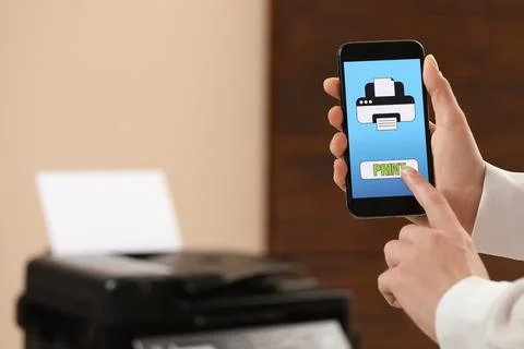 Man using printer management application on mobile phone indoors, closeup a.. Stock Photos