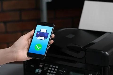 Man using printer management application on mobile phone indoors, closeup. .. Stock Photos