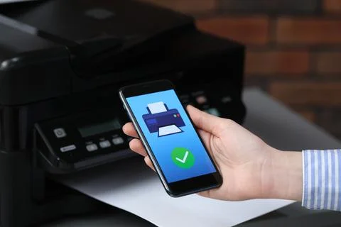 Man using printer management application on mobile phone indoors, closeup. .. Stock Photos