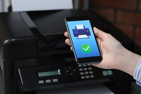 Man using printer management application on mobile phone indoors, closeup. .. Stock Photos