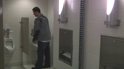 Man using a public bathroom, washing his hands and walking away. handheld shot Stock Footage 49863232