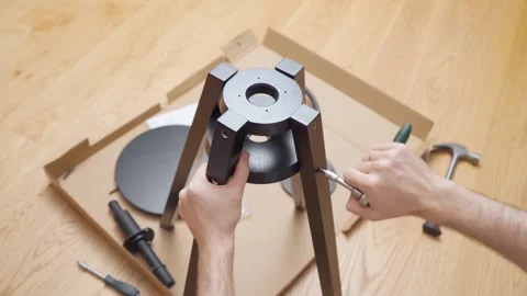 The man, using a ratchet screwdriver, manually screws in the screws. 스톡 동영상 261187844