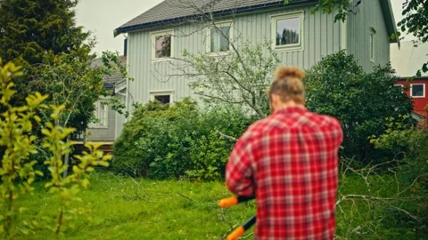 Man Using Reciprocating Saw to Cut Tree Branches - Norway Stock Footage 345529760